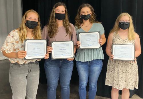 Four high school female students receiving a scholarship