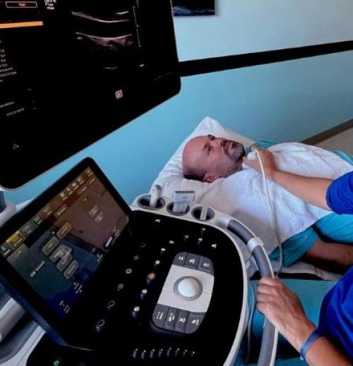 Imaging Technician using an ultrasound machine to see the veins in a patients neck
