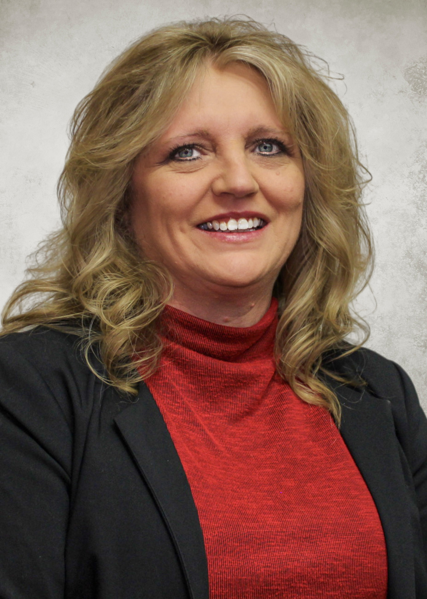 Blond Haired Woman with red shirt and black suit jacket